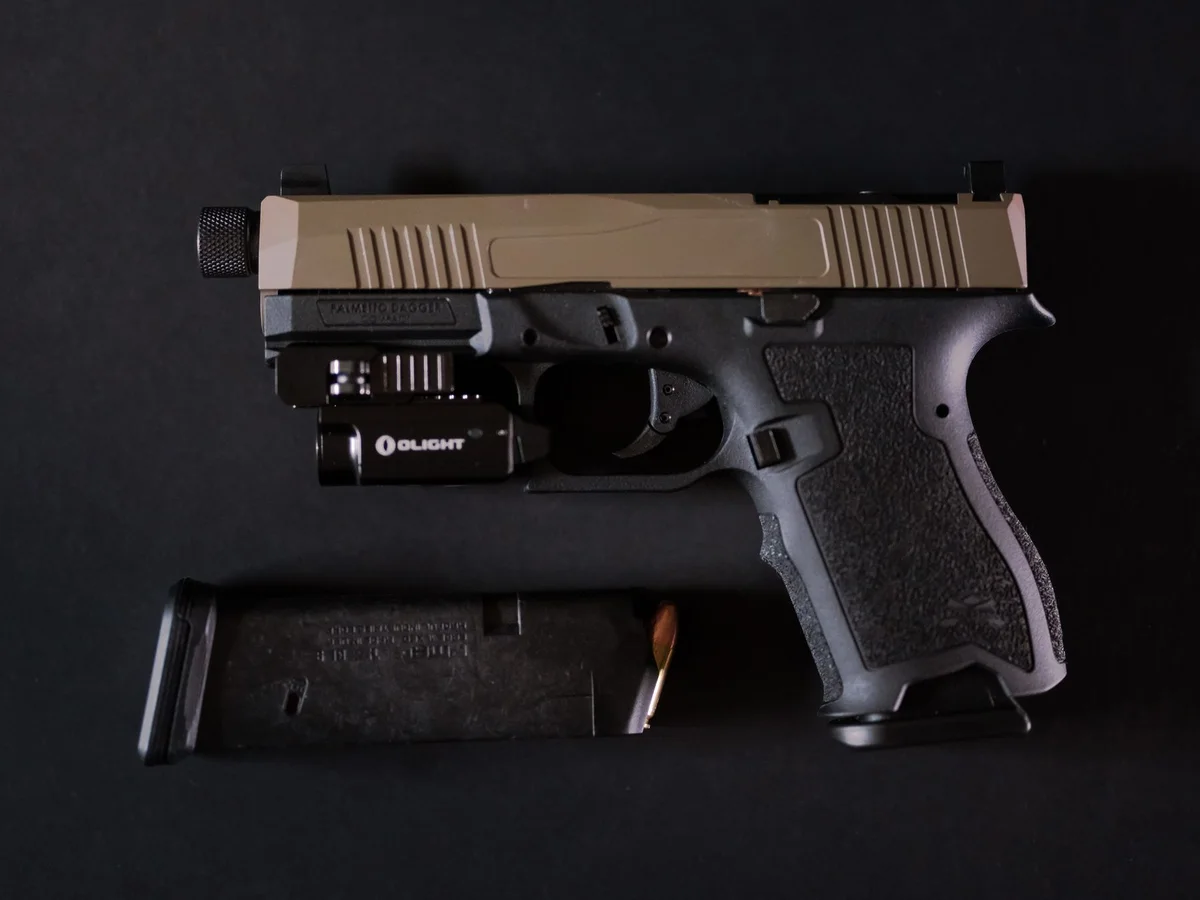 Detailed handgun and magazine against a dark background