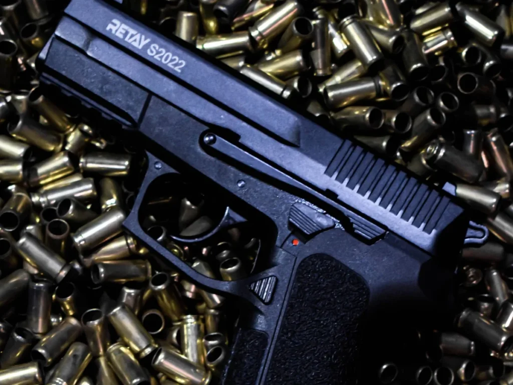 Handgun photographed above a field of cartridge cases