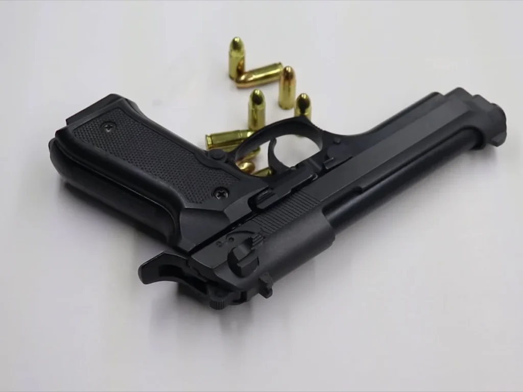 Handgun and cartridges arranged on a light surface