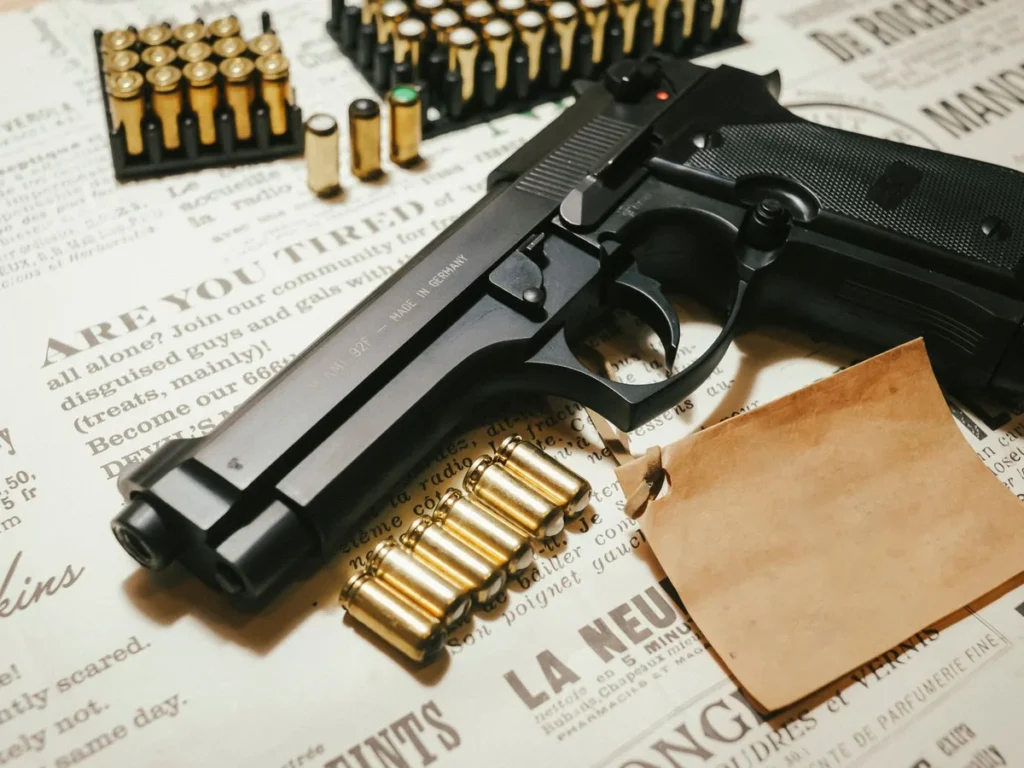 Handgun, magazines, and cartridges arranged on vintage paper