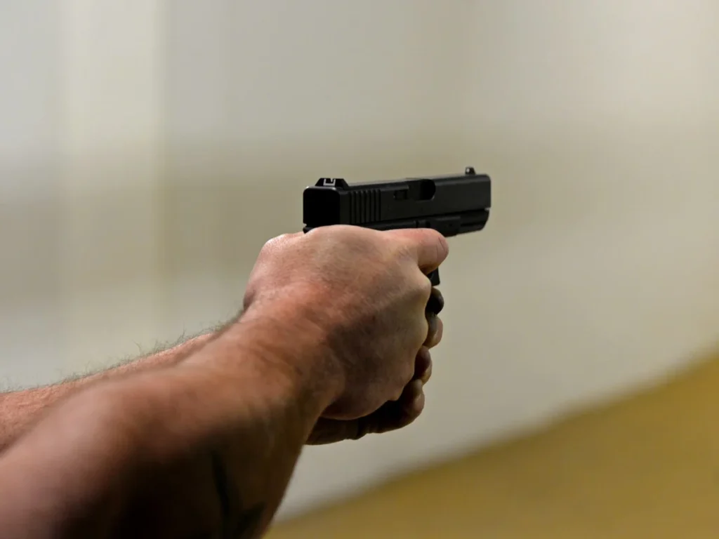 Shooter practicing with a handgun at an indoor range