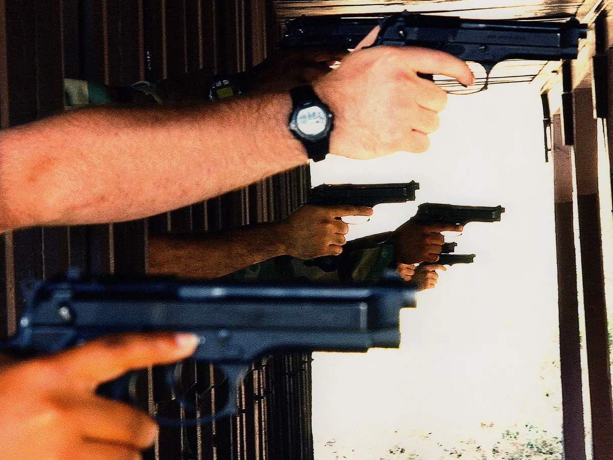 Multiple shooters practicing with handguns at an outdoor range
