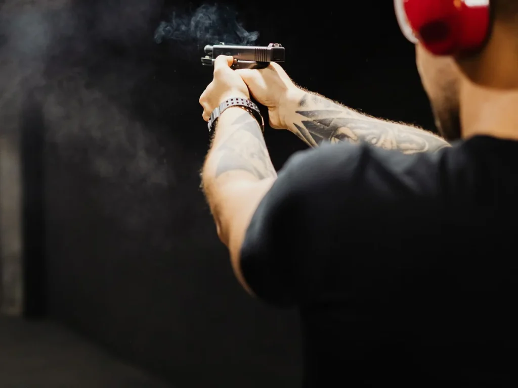 Shooter wearing ear protection in an indoor handgun lane