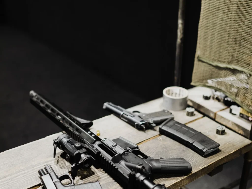 Firearms and components arranged on a range workbench