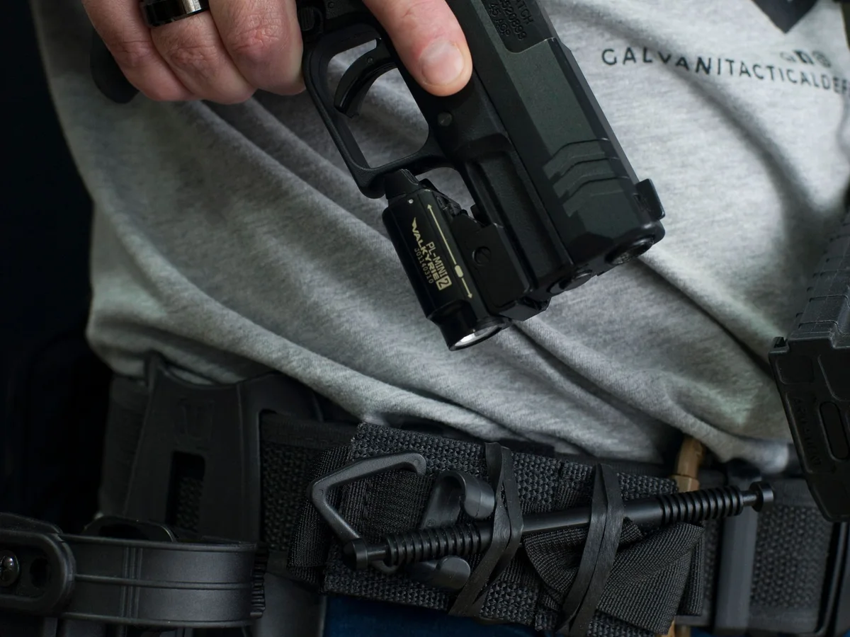 Handgun handling beside a tactical belt and holster