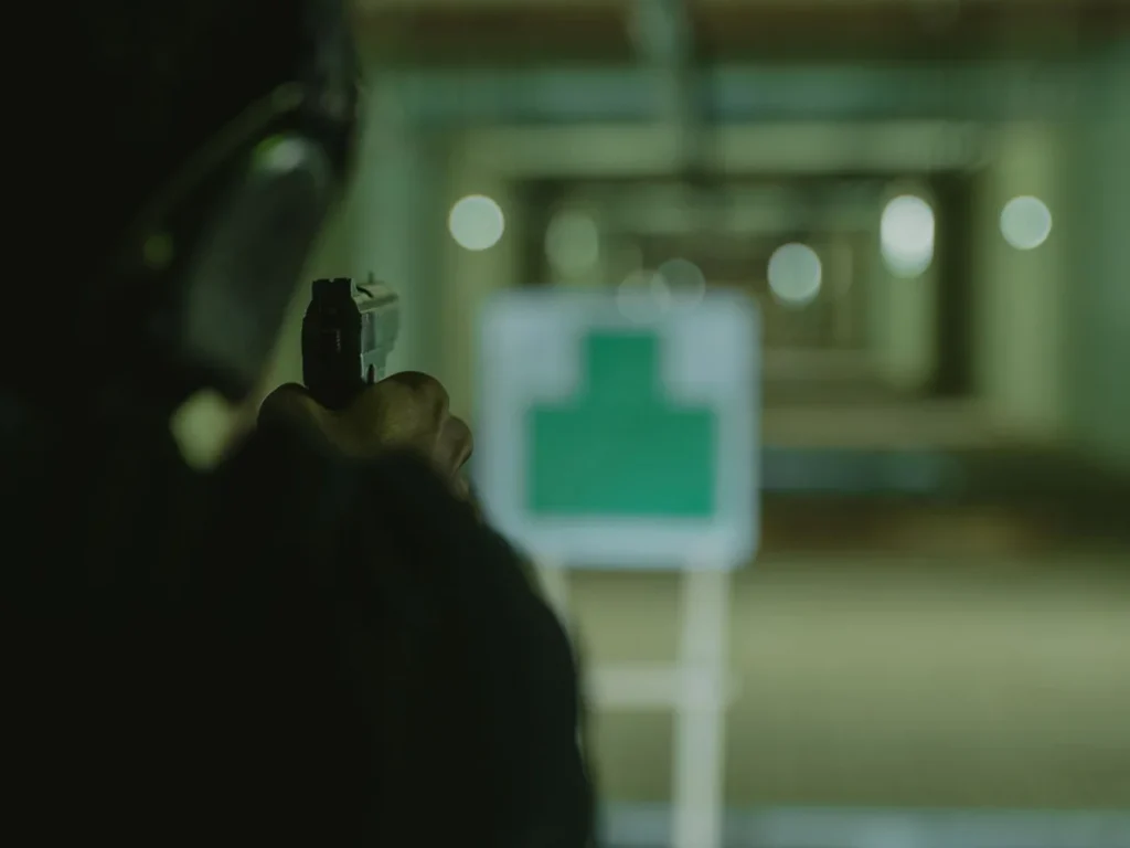 Handgun practice in a dimly lit indoor shooting lane